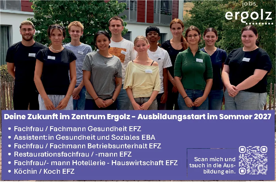 Zehn junge Auszubildende stehen lächelnd nebeneinander vor einem Garten mit Bäumen.